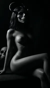 (masterpiece, best quality, photorealistic), ((monochrome:1.6)), ((black and white only:1.5)), darkened ritual chamber or empty stone interior, soft underglow lighting nude woman seated or reclining on hard surface, ((legs fully parted in confidence:1.8)), inner thighs and folds softly exposed in contrast light, ((body flawless, erotic, reverent:1.8)), — smooth skin, tidy bush, full breasts, narrow waist, soft curve of belly, moisture visible between parted folds, ((wearing primal animal skull mask:1.9)), — bone texture, elongated snout or antlers, eye sockets empty, face fully concealed light source low, illuminating her sex, hips, and chest — face shadowed, mask dominant in silhouette camera low and frontal, focus centered between thighs, mask blurred or framed above — **body revealed, identity hidden** atmosphere sacred, ancient, deeply erotic — **she is not woman. She is offering**, <lora:ral-chrosc-bw:1.2>, <lora:dark:.7>