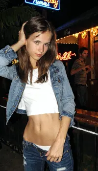 --style raw, -no text, -no watermarks, one 27 years old skinny very drunk woman Stands near the disco bar, leaning against the palm. Night. femboy skinny body type, jeans jacket, long simple white T-shirt, tilted head, long dark brown hair, Detailed, natural, skin, and, blemishes, without-makeup, acne, <lora:skin_4-000015:.5>