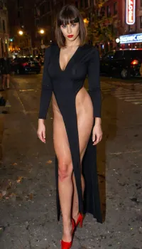 Busty woman standing front, brunette, short bobcut with bangs, Candid photo, UHD 8K, photorealistic 33-year-old busty woman, slim waist, wearing a black long cotton deep slit dress looks like V-suit, red high heels, no make-up, street in New York City, night scene, realistic well-detailed eyes, soft features, wide hips, facing the viewer, happy, neon lights, (happy:1), (deep slit:1.4), (torn:1.1), vswimsuit, <lora:Vswimsuiti_XL_reg0_-000004:1.5>