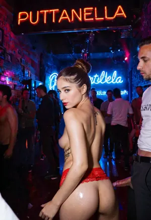 Puttanella, una joven italiana, está en un club nocturno cuando conoce a varios hombres que están interesados en ella. La llevan a la pista de baile y empiezan a follarla duro. La imagen muestra Puttanella con un máximo de cinco