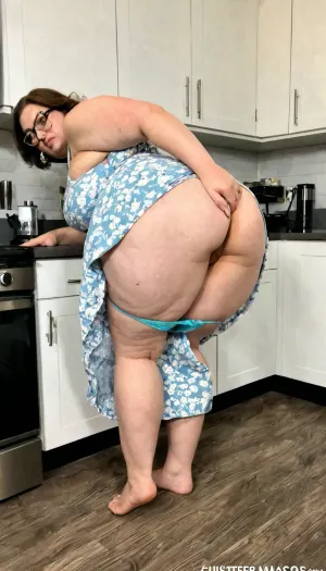 La vecchia era seduta al bancone della cucina, indossando un vestito corto e occhiali. Si stava piegando su un piccolo contatore della cucina, guardando qualcosa sullo schermo del suo telefono. Il suo culo era agitato mentre si muoveva, e lei