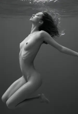 一个黑白的AI生成的裸体女子在水中潜水的图像,带有感官曲线,完美的皮肤,完美的身体,使她看起来像是游过宇宙