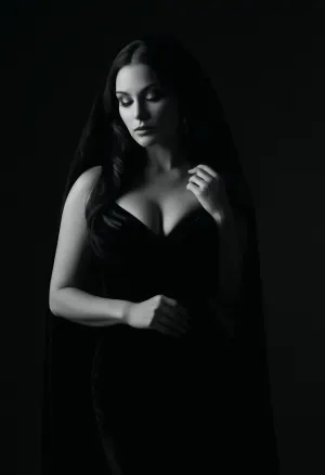 (Award-winning, evocative black and white photograph, upper body portrait:1.8), (silhouette of a curvaceous woman in a graceful and elegant pose:1.7), (the suggestion of feminine curves subtly defined by light and shadow:1.6), (artistic study of the feminine form, focusing on shadow and texture:1.6), (dramatic chiaroscuro lighting:1.7), (high contrast, deep shadows obscuring details:1.4), (unseen light source creating a soft halo:1.3), (elegant raven black hair, body hugging velvety black dress, sheer black veil:1.5), night, dark room, mysterious, dreamlike, sensual atmosphere, delicate, fragile, poetic, poise, elegant, sensual, feminine, artistic, ziprealism