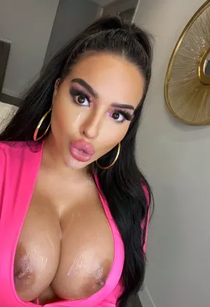 Selfie, headshot, 8k, intricate details. A gorgeous latina bimbo, looking up at viewer, big dark eyes, big glossy pink lips, pouting, vibrant makeup, long thick eyeliner, big fake eyelashes, beautiful long dark hair, huge thick gold hoop earring, eyeliner, graphic eyeliner, thick eyelashes, dark skin, busty, cleavage, clothed in pink latex, bmbplora, cum facial, cum plastered, cum dripping down, <lora:406734_training_data:.5>, <lora:bimboxl_02:.6>, <lora:clothed_small:.5>, <lora:1122530_training_data:.6>, <lora:Pouting_SDXL:.6>