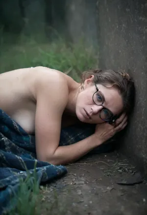 Create an intense, cinematic art evocative portrait. 32 yo girl, ((naked)), with short brown curley hair, rectangular glasses with black rim, brave, scared but serious, heavy rain weather, the rain wet his face, the field is transformed into a apocalyptic landscape., ((Colourful patterned, over hip-length woollen jumper)), bottomless, ((lying on stomach)), (she is fucked from behind by dirty homeless man:1.8), rough, rough sex, (hair pull), . The delicate Details and dark colors make this a truly unique and captivating image. Deep blue eerie light, eyes open in a moment of raw emotion. The blue and black palette intensifies the mood, evoking a sense of mystery and allure. Subtle film grain and metic, purple and blue is main color, energy around, shining, glow