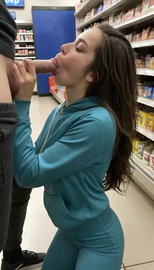 candid photo of a young brunette woman taken at a convenience store during the night, low quality image, exhibiting a grainy texture, jpg artifacts, film grain, gritty, raw aesthetic Form-fitting, snug, close-fitting, constrictive sweat suit, giving a sloppy blowjob with hand down pants