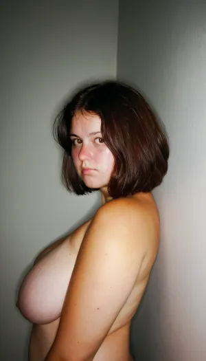 Raw pictures, shy modest tired curvy woman leaning against a wall in the office, (thick body:1.2), natural saggy boobs, (:1.4), bad light, dark light, disheveled hair, hair cut in bob, straight dark brown hair, natural skin, visible pores, freckles, slight acne scars, redness around the nose, and uneven skin texture, high quality, Best quality, realistic, person in the frame but poorly centered, partially cropped out, off-frame composition, head cut off, awkward camera angle, unbalanced shot