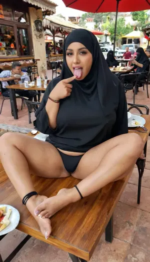 A sexy chubby arab dark skinned muslim woman with black hijab showing off her feet on a restaurant table outdoors, food on the table, people sitting the background, colours are candid shots she is wearing a black g string, her mouth is wide open and her tongue out, she is doing the quiet sign with her hand, (thighs), (restaurant), (muslim), (bare feet), (feet), (ankle bracelet), (black abaya), (black hijab), (tongue out)