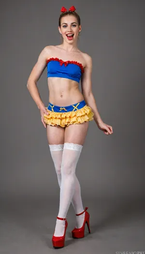 a cross-dressing man—smooth-skinned, (((real man))), (((male crossdresser))), and clean-shaven—wearing blonde hair, feminine makeup, ahegao expression.He appears full-body in the image. Crazy smile, very happy face, tonge out. flat, he wears Ultra sexy Snow White version, blue strapless crop top with red off-shoulder ruffles and red bow detail at the center, yellow ruffled tulle mini skirt, yellow garter belt with straps, white thighhigh stockings with red bows at the top and garter straps, red high-heeled platform shoes, no text or logos anywhere, pure sexy fantasy outfit, holding a red apple in one hand, white background, photorealistic, full body pose with one leg slightly lifted, 1twink