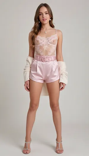 A girl, wearing, Sheer lace bodysuit with floral patterns in blush pink.
High-waisted satin shorts with a matching pink belt.
Strappy stiletto heels with rhinestone details.
Pearl drop earrings and a dainty heart-shaped necklace.
Soft cashmere shawl for a touch of elegance.
