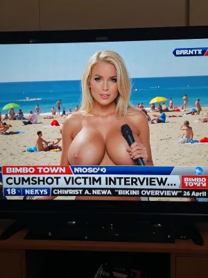 TV screen, news show, sexy girl, blonde sensuous female news anchor на людном нудистском пляже с микрофоном, revealing giant naked breasts, news ticker, 18 yo., co-anchor, BIMBO TOWN news, "CUMSHOT VICTIM INTERVIEW...", "BIKINI OVERVIEW" "26 april".
