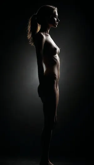 Image of a skinny woman, side view, sharp silhouette, slim body, perky breasts, sexy pose, naked. Dark background creating the impression of fog. High contrast, bright backlight, <lora:dark:.6>