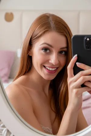 an intimate mirror selfie of a bashful milf awkwardly attempting to be seductive in her cozy bedroom with minimalist feminine decor, she holds a phone up near her face while the edges of the mirror frame the photo subtly, the photo focuses on her adorable mousey face with prominent overbite and awkward goofy lopsided grin as she blushes shyly, huge expressive eyes in a mischievous coy glance as she surprises and embarrasses herself with her flirty boldness, she has a triangular face with soft coppery ginger hair, her amateur pose is adorably awkward and bashful, showcase of girl-next-door non-conventional beauty, she's teasing the viewer with the slightest peak at her lacy bra