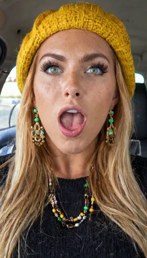 Büyük ağız ve freskler olan kız bir kızın sinematik fotoğrafı için hazır, bir Amerikalı beret, siyah terer ve makyaj giyiyor. Yüksek Tan hatları ve mükemmel yeşil gözleri var. Uzun saçları bir pony