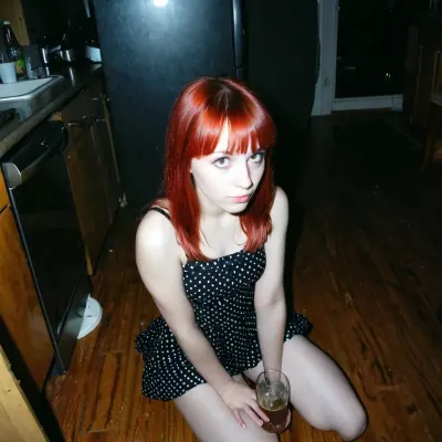 L'introverso ragazza rossa grunge con bangs, catturato in un angolo buio a una festa nel 1997, era sempre alla ricerca di qualcosa di più che solo adattarsi e conforme alle norme sociali. La sua macchina fotografica era la sua compagna mentre catturava