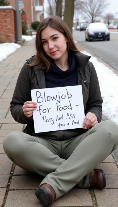A woman in dirty clothes sits on a sidewalk, holding a handwritten sign that reads "Blowjob for food, pussy and ass for a bed." She is wearing dirty clothes and has her hair tied up in messy bun. Her face is covered