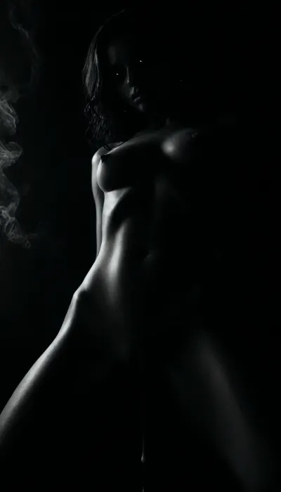 (masterpiece, best quality, photorealistic), ((monochrome:1.6)), ((black and white only:1.5)), ambient void lighting, deep shadowed black room with no walls, pure negative space woman standing fully nude in the center, legs slightly apart, posture still and powerful, ((cum-slick pussy dripping slowly:1.6)), thighs streaked, fluid trailing toward the floor, ((smoke billowing from her skin:1.7)), rising in soft strands from her shoulders, belly, and cunt, glowing faintly in contrast, ((eyes glowing deep red:1.5)), locked forward, calm and haunting—gaze of something no longer human skin glistening with sweat, body still trembling from recent orgasm, mouth slightly open camera positioned low and frontal, focused on the glistening between her thighs, the smoke rising, and her burning stare atmosphere dead silent, sacred and violated—she is the altar, the flame, and the ash, ((selective color, red)), <lora:ral-chrosc-bw:1>, <lora:dark:1>