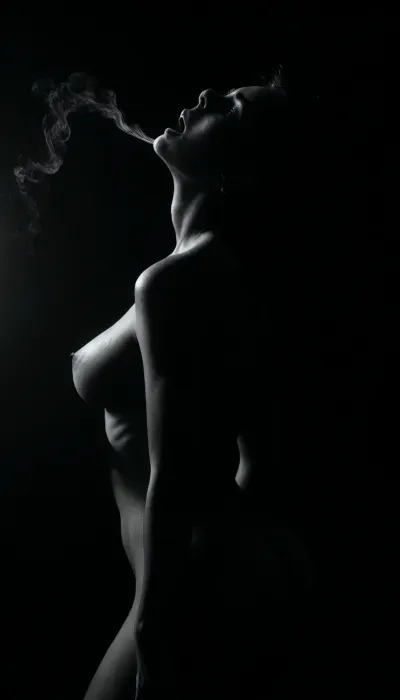 (masterpiece, photorealistic), ((monochrome:1.6)), ((black and white only:1.5)), ritual lighting, smoke swirling around her woman standing, naked, drenched, arms lifted back, thighs parted, ((back arched deeply:1.5)), ((head thrown back in surrender:1.4)), face to the sky red eyes glowing through shadow, tongue exposed, cum trailing down her belly, cunt wet and gaping from earlier use camera low and wide, capturing the power and ruin of her form in holy stillness, ((selective color, red)), <lora:ral-chrosc-bw:1>, <lora:dark:1>