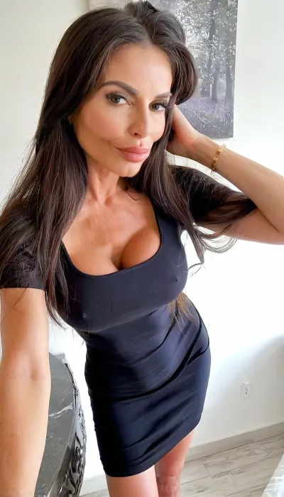 Selfie, Standing in front of me about to give me a blowjob cool pose, nonchalant hippie, ((fully clothed)), (sexy old skin), ((black long dress)), ((breathtaking Italian brunette bimbo MILF 60yo old botox)), beautiful instagram model, very beautiful, perfect skinny body, smooth silky long hair, perfect face, bimbo, tanned skin, looking at the camera, perfect eyes, sexy, sensual, (skinny fit), pretty, snub-nosed, long hair, seductive image, 4ng3l, face, (crop, top:1), teasing, bmbplora, <lora:SDXL_BetterFaces-LoRA_v1:.8>, <lora:cfg_scale_boost:.8>, <lora:clothed_small:1.7>, <lora:bimboxl_02:.8>