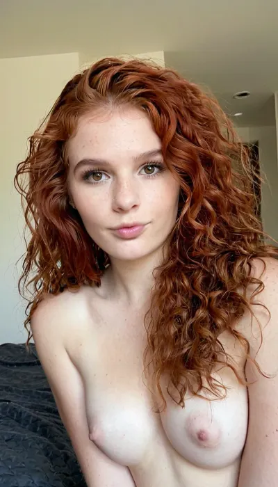 Je veux que tu génère des photos très réaliste d'une femme de 35. Elle est rousse. Les cheveux bouclé.