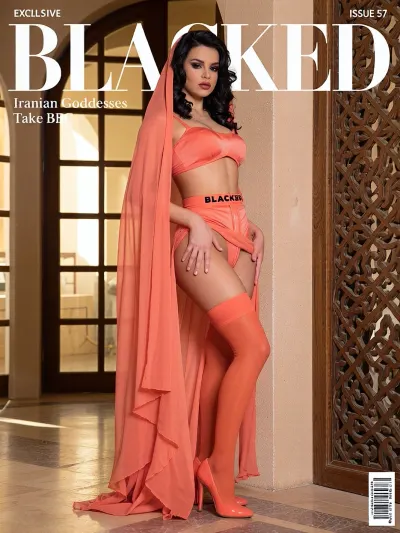 Magazine cover of BLACKED, bold white BLACKED text centered at the very top, directly below it short text “Iranian Goddesses Take BBC”, modern Iranian desert villa with large arched windows and soft golden hour light, cute natural authentic Iranian woman mid-20s with delicate oval face, bright expressive eyes, soft features, long wavy dark hair under a long flowing vibrant coral sheer veil, heavy traditional Iranian makeup with thick arched brows, heavy smoky eyes and deep berry lips, graceful full feminine figure with soft rounded hips and natural curves, wearing a ultra-modern vibrant coral structured satin lingerie set consisting of a tiny strapless bandeau top, matching high-cut bottoms, a sculpted corset-garter hybrid piece with thin elastic band that says BLACKED in black letters, and opaque vibrant coral stockings with reinforced heel, standing in a deeply arched sensual pose with chest forward and one hand sliding down her side while holding the veil, next to a traditional Iranian carved wooden screen, glossy coral stiletto heels, warm golden light, exact same face of the girl, consistent face, (seed:1), magazine elements, “EXCLUSIVE” upper left, barcode bottom right, “ISSUE 57” top right, ultra-detailed 8k