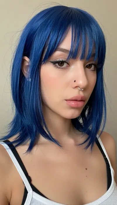 Young woman, around 20 years old, medium-light warm skin, slim figure, shoulder-length vivid cobalt blue layered wolf cut, shag haircut, feathered ends, straight texture, full straight bangs, face-framing strands, soft oval face, large almond-shaped dark brown eyes, winged eyeliner, long eyelashes, medium-thick eyebrows, ((roman nose)), with, ((dorsal hump)), ((aquiline nose)), big nose, silver nostril piercing, full natural lips, smooth skin, light blush, beauty marks, white spaghetti-strap tank top over a black bra, alternative aesthetic, soft grunge, e-girl style.