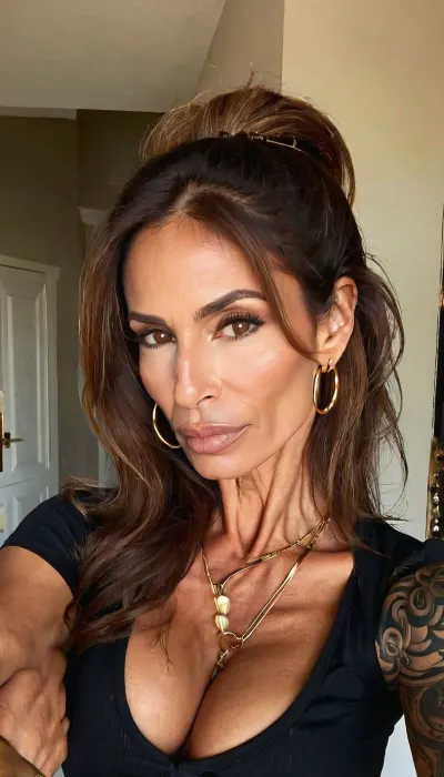 lazy eye, leaning towards me, holding her tits, small fake tits cleavage, vneck black tee, ((old, 50yo)), handcuffed, gold hoop earrings, nose ring, tattoos, sexy neck, ((old brown hair mom woman)), (tan skin), (skinny muscle), (beautiful Mexican instagram model face), (fit body), very beautiful, perfect skinny body, perfect face, looking at the camera, perfect eyes, (skinny fit), pretty, snub-nosed, long hair, 4ng3l, face, <lora:clothed_small:1.8>, <lora:SDXL_BetterFaces-LoRA_v1:.8>