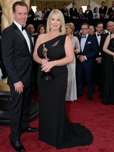 stunningly beautiful 38 years old woman, (voluptuous:1.8), (extremely top heavy:1.8), receiving an Oscar for best actress on the podium in front of a well dressed crowd