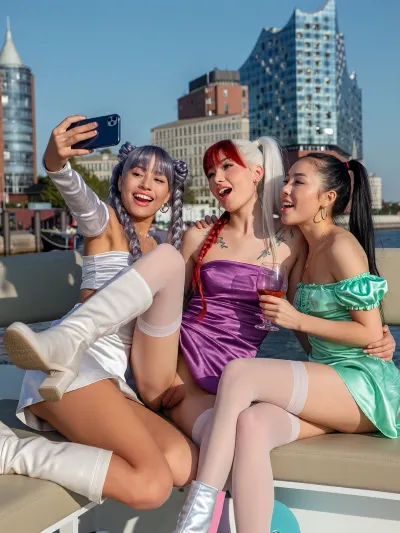 4 Asian African girls, Korean, Chinese, Japanese, doing a funny selfie shot with iPhone 17, they are wearing satin mini dresses with long boots and off shoulder top, they have long hair and braided pigtailed and ponytail hair, silver, lilac and red white green hair, flat chested, tattoos, luxury perfect makeup, they sitting together on a boat near the elbphilharmony, (one leg up:2), Harbour, outside, Hamburg, public, perfect architecture, sunshine, nice light, drinking cocktails, hug, smiling and talking, spread open legs with stockings, (crowd:1), (show gaping pussy:6)