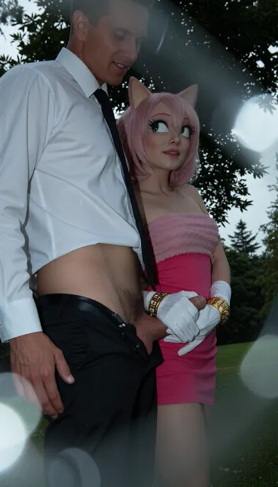Create a candid snapshot in the style of a late-1990s/early-2000s disposable 35mm film camera, the depth of field is razor-thin, blurring the foreground into soft out of focus, tactile bokeh, nightmare atmosphere, dark and unsettling mood, lower angle view, Amy Rose from the Sonic the hedgehog, anthro, (Amy Rose have her white gloves with golden bracelets), Amy Rose small body, flat boobs, she is wearing her pink dress on top of her, (very detailed and accurate Amy Rose pink dress), male anon, male anon is wearing white buttoned down office shirt, black office trousers, (his black office trousers are lowered down so that his penis is visible, (perfectly shaved penis), Male anon is standing, Amy rose is standing behind male anon, Amy Rose is holding his penis with her hand from behind, (handjob), side view, (view from side), smiling, in a public park, masterpiece, professional image, very detailed image, 4K image), A low-resolution photo taken with an early mobile phone, the photo was taken in an amateur, candid manner, uncontrolled shadows. The background falls into complete darkness, Use a cheap consumer film camera aesthetic, 35–40mm equivalent lens, moderate depth of field, slight softness, imperfect autofocus, mild vignetting, uneven exposure, and natural perspective. No modern digital sharpness or smartphone processing.

Film look should include visible grain, slight color noise, halation around highlights, faded blacks, and imperfect white balance. Colors are cold from flash, with blue shadows, muted greens, and slightly faded tones. The image should resemble a scanned 35mm print.

Include authentic film imperfections, dust, tiny scratches, subtle motion blur, and exposure inconsistencies. Everything should feel organic, not added or artificial.

forground dissolving into soft bokeh, cool and muted tones, rust and pale grey palette, analogue film, heavy grain, scratches and film imperfections, Kodak Portra 400 underexposed, cool and melancholic, the woman sharp against the soft dissolved background, quietly devastated