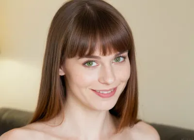 Professional portrait photograph of a beautiful skinny russian woman in her 40s, medium-length straight dark brown hair with full straight-cut bangs, striking light green hazel eyes, fair porcelain skin with natural flush, oval face shape, warm genuine smile showing white teeth, long natural eyelashes, delicate facial features, natural makeup look, soft natural lighting, studio portrait, photorealistic, highly detailed skin texture, sharp focus on eyes, 85mm lens, f/2.8, professional photography, ultra realistic, 8k quality, detailed irises, natural skin pores visible, candid friendly expression