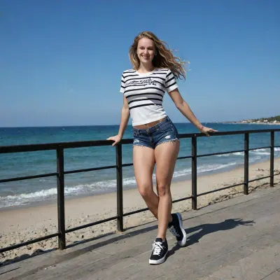 Young woman, (petit:1.2), (short stature:1.4), (slim girl:1.1), (slim abdomen:1.1), (white skin:2), (pale skin:1.4), (young face:1.2), blonde wavy hair, (long hair:1.3), (hair stirred by the wind:1.2), (large breasts:1.3), busty boobs, (thick legs:1.4), (wide hips:1.2), large buttocks, soft smile, looking to the side, ., .
standing, (fullbody view:1.5), relaxed pose, one hand near her hair, (black and white striped t-shirt:1.3), (denim shorts:1.3), oversized wide skate shoes, chunky skate sneakers, .
urban boardwalk by the beach, malecón, ocean in the background, concrete railing, (very sunny day:1.5), (bright sunlight:1.4), strong natural daylight, clear blue sky, photorealistic, high detail, sharp focus, <lora:maniacal_laughter:.6>, badquality, low, quality, <lora:badquality_v02:.8>