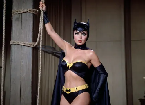 1960's Batman TV series, 35mm color film. Full body shot, Yvonne Craig playing Batgirl is tied up with ropes and her ample chest is exposed. Batman arrives to save Batgirl.