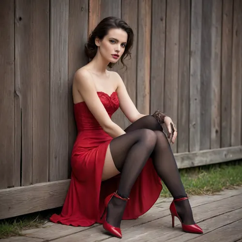Fashion Photograph Highlights Elegance Against a Rustic Backdrop

A fashion photograph set against the weathered wooden wall of an outdoor structure presents a carefully composed contrast between refinement and roughness. The image features a woman seated on the ground, her posture relaxed yet deliberate, one arm bent and resting near her head, the other placed calmly along her leg. Her direct gaze toward the camera conveys composure and quiet confidence.

She is dressed in a strapless, flowing red dress made of lightweight fabric that falls in soft layers around her legs. The vivid red stands out sharply against the muted browns of the wooden wall and the pale ground beneath her, immediately drawing the viewer’s attention. The dress is styled with sheer black tights, adding a subtle layer of texture and restraint to the overall look.

Her accessories are striking but controlled. She wears long brown leather gloves that reach past the forearms, introducing a structured, almost vintage element to the outfit. A wide gold bracelet adds a touch of formality and visual weight. On her feet are red lace-up heels, their thin straps wrapping around the ankles and echoing the color of the dress while reinforcing the elegance of the styling.

Her dark hair falls naturally past her shoulders, parted at the center, and her makeup is understated, allowing the clothing and composition to remain the focus. Overall, the image reads as a deliberate fashion statement, using strong color, classic accessories, and a rustic setting to explore contrast, poise, and modern femininity.