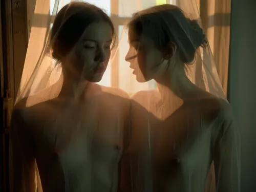Fine art cinematic photography, Francesca Woodman aesthetic, extreme soft focus, heavy analog grain, Kodak Portra 800 pushed two stops, warm amber and deep shadow, the blur the primary mood of the image.

Portrait with a focus on faces and tiny breasts, Two very yyoung woman behind a sheer curtain, her form entirely dissolved through the gauze, dark hair loosely pinned, the curtain between the viewer and the figure absolute, she exists as suggestion rather than subject.

A soft golden backlight through the curtain, the light through the sheer fabric in warm amber and gold, the curtain catching and diffusing the light into something molten, deep shadow at the edges consuming the frame. A rustic window barely visible behind sheer curtains. Extreme soft focus throughout, nothing sharp anywhere in the frame, the woman dissolved into light and gauze and grain, warm amber and deep green shadow, intimate and voyeuristic, glimpsed not seen, the curtain keeping its secret.