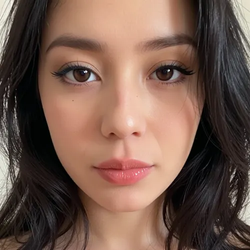Composition
Close-up, vertically framed portrait from slightly below eye level.
Her face occupies most of the upper and central frame.
Head is nearly straight toward the camera, with only a very subtle natural tilt.
Shoulders and upper torso are visible at the bottom.
The camera is quite close, producing a mild wide-angle effect, the central facial features appear slightly more prominent.
Face shape & proportions
Face has a soft, rounded-oval structure, with a relatively broad upper face and gently narrowing lower face.
Forehead is moderately broad and mostly concealed around the edges by her hair.
Cheek area is full and softly contoured rather than sharply angular.
Jawline is smooth and rounded.
Chin is moderately broad and softly curved, without a pronounced point.
The face has relatively balanced vertical proportions, with the eyes around the upper-middle portion of the face.
Eyes & eyebrows
Eyes are dark brown to nearly black, large and almond-shaped.
Both eyes are directed almost directly toward the camera.
Upper eyelids are quite prominent, with naturally dark lashes.
The eye openings have a slightly elongated horizontal shape.
Eyebrows are naturally dark, fairly thick, and gently arched rather than sharply shaped.
There is a moderate distance between the eyebrows and the upper eyelids.
Nose
Nose is relatively broad at the bridge and becomes wider toward the nostrils.
Bridge is smooth and moderately short in appearance.
Tip is rounded and softly defined.
Nostrils are clearly visible because of the camera angle.
Avoid making the nose overly narrow or sharply sculpted—the photograph shows soft, rounded contours.
Mouth & lips
Lips are naturally full, particularly the lower lip.
Upper lip has a gentle, defined Cupid's-bow shape.
Mouth is relaxed and closed, with a neutral expression.
Corners of the mouth are approximately level.
There is a subtle natural shadow around the mouth and beneath the lower lip.
Hair
Very dark/black, thick hair, extending well below the shoulders.
Hair is naturally wavy with loose curls/sections rather than perfectly straight.
A substantial amount of hair frames both sides of the face.
Hairline is irregular/natural and partially obscured by loose strands.
Several individual strands fall across the left side of the face.
The hair has considerable volume, especially around the sides and lower portion.
For a realistic sketch, retain the flyaway strands and uneven natural texture rather than making it look salon-styled.
Skin & lighting
Medium-to-deep warm brown complexion with subtle variation across the face.
Skin should be rendered with soft tonal transitions, not as a flat uniform color.
The strongest light appears to come from the upper/front area, producing highlights on, forehead, bridge/tip of the nose, upper cheeks, lower lip.
The eye sockets, hairline, sides of the face, and neck are considerably darker.
The photograph is somewhat underexposed, so the painter should not over-light the shadows.
Chubby, large, naked