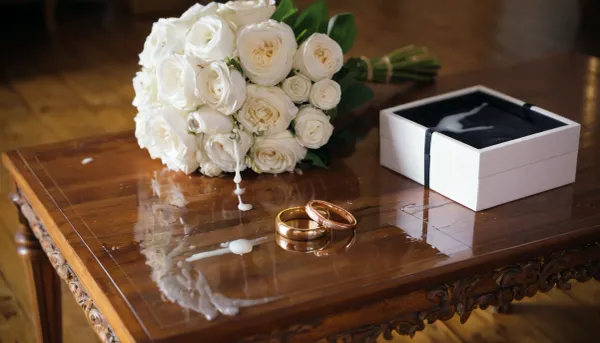 A luxurious bridal bouquet, elegantly arranged and placed next to an open velvet wedding ring box showcasing two shiny gold wedding rings. cum is oozing over the bouquet and dripping onto the rings and their box. Some of the cum has spilled onto the wooden table surface, creating reflective, sticky puddles. The scene is beautifully lit with natural soft light, creating a romantic yet surreal contrast between elegance and the unsettling presence of the cum.

hyper-realistic, elegant, cinematic lighting, macro lens, depth of field, soft shadows, luxurious, surreal, detailed textures, reflections