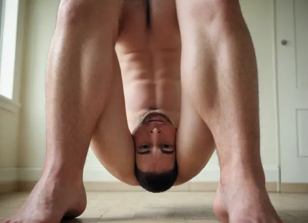 Man's abs and stomach. Man with his knees up. Lower body of squatting man