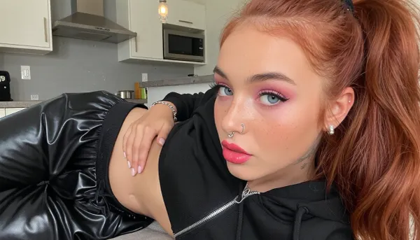 european asian girl, 18 years, anorexic, petite, extreme skinny, red hair, redhead, high ponytail, tanned skin, blue eyes, ((freckles, rouged cheeks, pink eyeshadow, intense saturated magenta lipstick, black mascara, long strong eyelashes)), tattoos, nose piercing, belly piercing, earrings, bracelets, wide shiny black jogging pants, wide zipped black shiny hoodie, in a kitchen of a modern villa, ((face, close up))