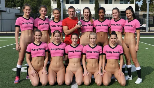 A photo of a sports team. The team consists of twelve standing and squatting naked women arranged in two rows. They are wearing only simple pink sports jerseys with black trim with the inscription "Pussy Power". All the women have perfectly shaved vaginas. They are all looking at the camera. Happy after her victory, a woman holds a trophy up in the air. sports field in the background.