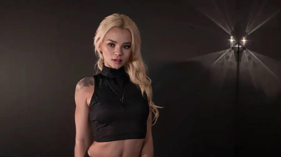 Fotoğraf en iyi kalitede bir başyapıttır, güzel bir aydınlatma ve siyah ceket ile. Kızın saçları tamamen besleniyor, ancak açık ağzı ve bared dişleri bir seductive vibe bırakıyor. Kolsuz kaplumbağası var